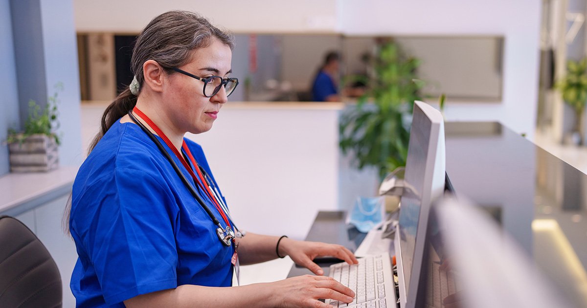 provider at desk entering data into computer provider sitting at a desk entering data into computer